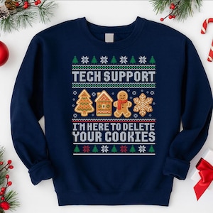 May include: Navy blue sweatshirt featuring a Christmas-themed design. The text "TECH SUPPORT" is above gingerbread cookie graphics and the phrase "I'M HERE TO DELETE YOUR COOKIES". The design includes Christmas trees, snowflakes, and gingerbread cookies.