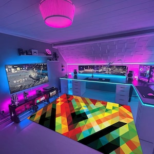May include: A colourful geometric rug with a black background and a 'GAME OVER' sign in the corner. The rug is in a room with a gaming setup, including a large screen TV, a computer desk, and colourful LED lights.