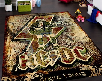 May include: A vintage-style rug featuring a graphic of Angus Young from AC/DC, playing a guitar with a lightning bolt behind him. The rug has a distressed, faded look with a brown, yellow, red, and black color scheme. The text "AC/DC" and "Angus Young" are printed on the rug.