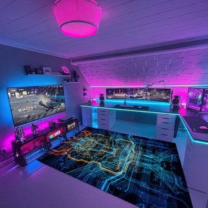 Può includere: Una stanza da gioco con un tappeto a motivi di circuiti stampati nero e blu, una scrivania bianca con un monitor per computer, una tastiera e un mouse. La stanza è illuminata da luci LED rosa e blu. Il testo "GAME OVER" è visibile su una scatola sulla scrivania.