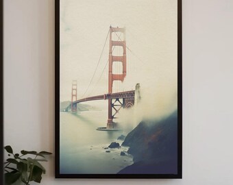 May include: A framed vertical wall art print depicting the Golden Gate Bridge in San Francisco. The iconic orange-red suspension bridge spans across water, partially obscured by thick white fog, with a dark rocky cliff visible in the foreground.
