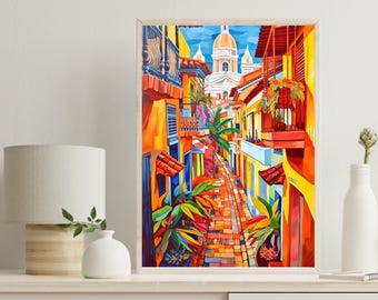 May include: A framed vertical art print depicting a vibrant street scene with yellow buildings, red-tiled roofs, lush green tropical plants, and a cobblestone path leading toward a white domed cathedral under a bright blue sky with clouds.
