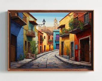 May include: A framed wall art print depicting a narrow cobblestone street lined with colorful buildings in shades of blue, yellow, and red. The scene features balconies with green plants, dark wooden doors, a black street lamp, and a distant tower.