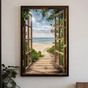 Puede incluir: Un cuadro rectangular que muestra un marco de ventana de madera abierto con vistas a una playa de arena, olas del mar y un cielo azul con nubes. Una pasarela de madera conduce hacia el agua, enmarcada por follaje verde.