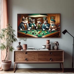 Puede incluir: Obra de arte enmarcada que representa a cinco gatos antropomórficos jugando al billar. Los gatos visten trajes, pajaritas y sombreros. La mesa de billar es verde y la escena se desarrolla en una habitación tenue con paneles de madera.