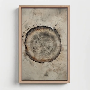 May include: A rectangular wall art piece featuring a high-contrast print of a tree stump cross-section with visible growth rings in shades of brown, gray, and cream, enclosed within a light-toned wooden frame with a clean, simple border.