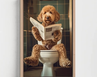 May include: A framed wall art print featuring a golden-brown curly-haired dog sitting on a white toilet whilst holding and reading an open newspaper. The dog has a fluffy coat and is positioned in front of dark green square bathroom wall tiles.