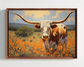 Puede incluir: Una impresión artística enmarcada que muestra una vaca longhorn con manchas blancas y marrones en un campo de flores silvestres de color naranja vibrante. El paisaje incluye una línea de horizonte lejana bajo un cielo pálido con nubes, en un marco de madera.