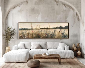 May include: A panoramic landscape painting in a thin wooden frame depicting a field of tall grasses and wildflowers in muted tones of beige, brown, and soft green, with a distant dark treeline under a pale, overcast sky.