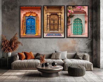 May include: A set of three framed wall art prints featuring architectural photography of ornate doorways. The left print shows a bright blue door with yellow garlands, the centre a carved wooden door, and the right a green door with pink flowers.