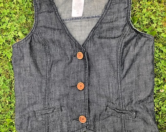 May include: A dark blue denim vest with a button closure and two pockets. The vest has a "dish" brand label on the front.