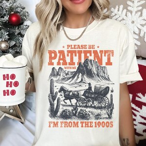a woman wearing a t - shirt that says please be patient i'm from