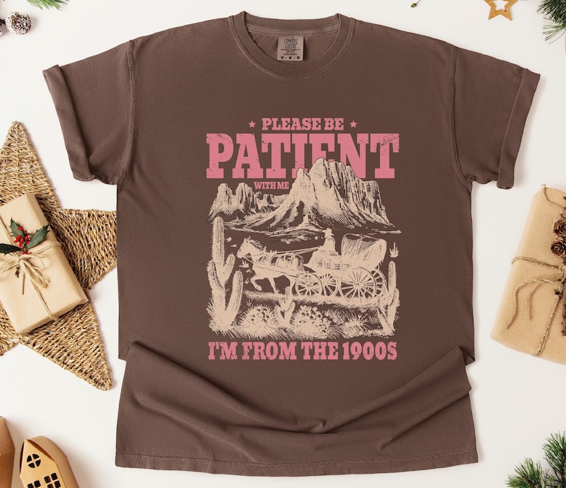 a brown t - shirt with a picture of a mountain scene