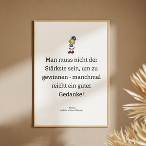 Könnte beinhalten: Ein gerahmter Druck mit deutschem Text und einer Cartoon-Illustration. Der Text lautet: "Man muss nicht der Stärkste sein, um zu gewinnen - manchmal reicht ein guter Gedanke!" Der Druck befindet sich in einem hellen Holzrahmen.