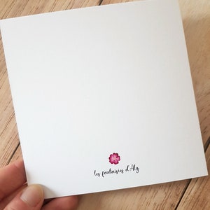 May include: A white card with a pink flower and the text 'les fantaisies d'Aly'.