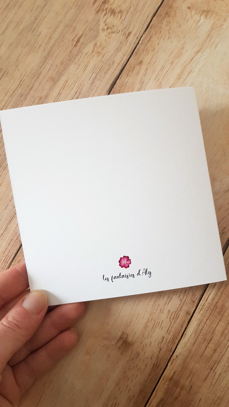 May include: A white card with a pink flower and the text 'les fantaisies d'Aly'.