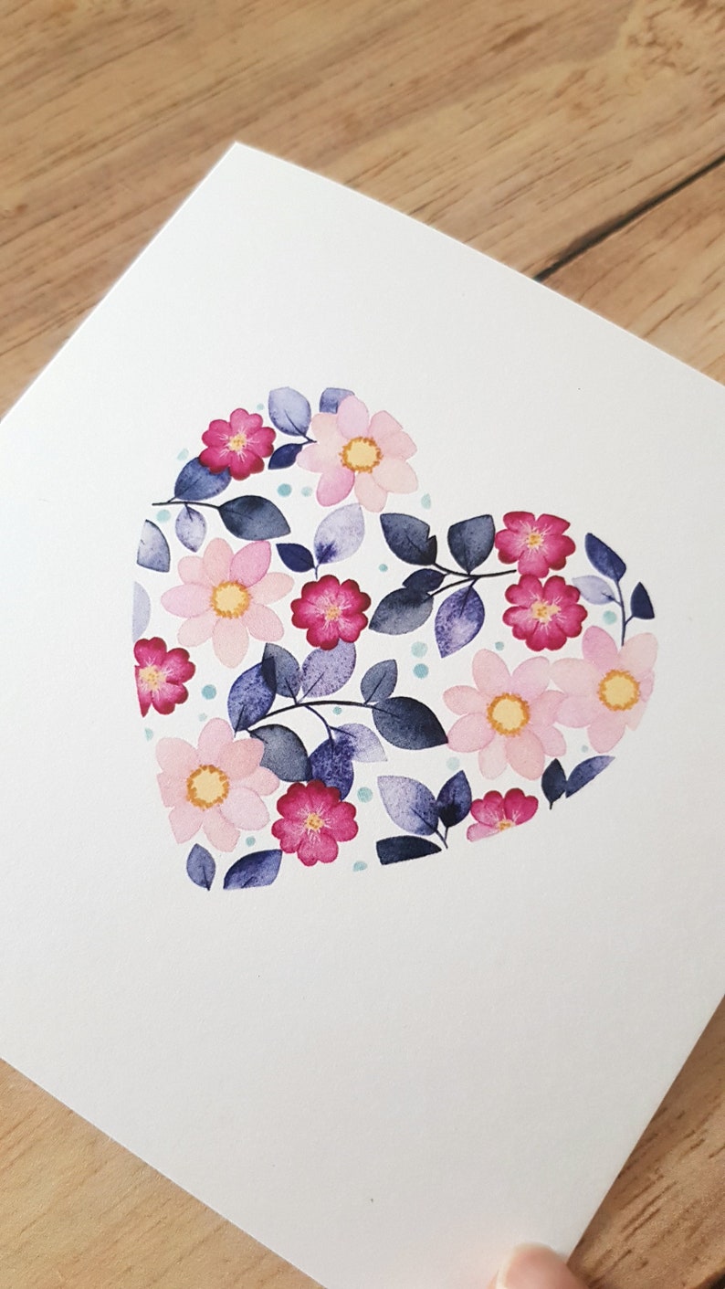 May include: A watercolor painting of a heart shape made of pink and purple flowers and leaves on a white background.