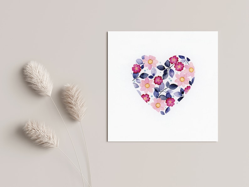 May include: A white card with a pink and blue watercolor heart design. The heart is filled with pink and yellow flowers and blue leaves.