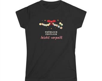 May include: A black short-sleeved t-shirt featuring a graphic of a string of colorful Christmas lights with a red bow and the text "FRÖHLICH FESTLICH leicht verpeilt" printed in white and pink lettering on the center of the chest.