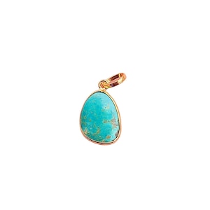 May include: A turquoise gemstone pendant with a gold setting. The pendant is shaped like a teardrop and has a smooth, polished surface.