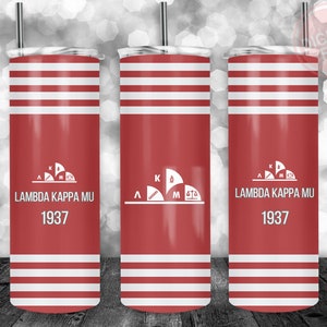 Könnte beinhalten: Roter und weißer Isolierbecher mit dem Text "LAMBDA KAPPA MU 1937". Der Becher hat einen roten Hintergrund mit weißen horizontalen Streifen und einem weißen Logo. Ein silberner Strohhalm ist im Deckel eingesetzt.