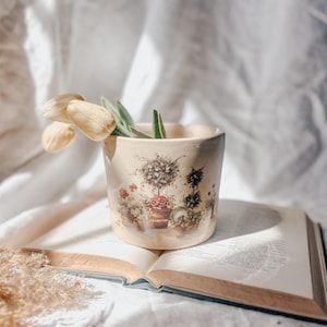 May include: A set of three ceramic mugs with a speckled, matte finish. The mugs are in shades of cream, light gray, and dark gray. Each mug has a simple, minimalist design, perfect for coffee or tea.