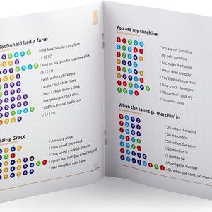 May include: A colorful booklet with lyrics for the songs "Old MacDonald Had a Farm", "Amazing Grace", "You Are My Sunshine", and "When the Saints Go Marchin' In". Each song has a corresponding color-coded chart with numbers.