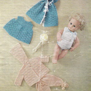 May include: A vintage crochet pattern featuring baby clothing. The image shows a blue hooded cape, a matching top, and a pink outfit with a jacket and pants. A doll and a rattle are also included. The text "Wendy" and "1106" are visible.