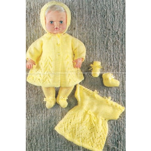 May include: A yellow knitted doll outfit with a matching hat, dress, and booties. The outfit is made with a delicate lace pattern.