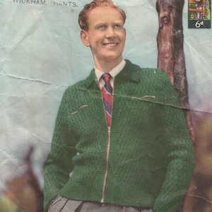 May include: A green knitted cardigan with a zipper closure and a red and blue striped tie. The cardigan has a cable knit pattern and two pockets.