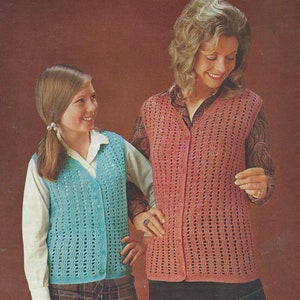 Peut inclure: Deux gilets en crochet, l'un en turquoise et l'autre en rose, avec un devant boutonné. Les gilets sont portés par deux personnes, une adulte et un enfant.