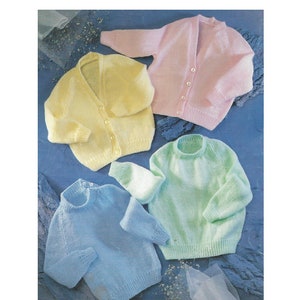 May include: Four knitted baby sweaters in different colors: light blue, light green, yellow, and pink. The sweaters are laid out on a blue surface.