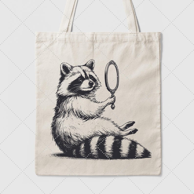 K&ouml;nnte beinhalten: Eine Schwarzwei&szlig;illustration eines Waschb&auml;ren, der einen Handspiegel h&auml;lt. Der Waschb&auml;r sitzt auf seinen Hinterbeinen und schaut in den Spiegel. Die Illustration befindet sich auf einer wei&szlig;en Tragetasche.