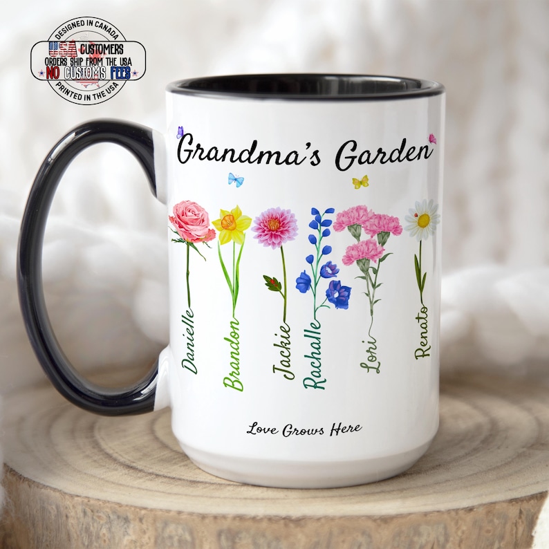 A white Coffee Cup with Black Accents, includes Kids Names and Flowers, This "Grandmas Garden" mug features six illustrated blooms labeled Danielle, Brandon, Jackie, Rachelle, Lori, Renato. Below reads "Love Grows Here"—a perfect Personalized Birth Flower Gift or Christmas Present for Mom and Grandma.