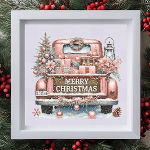 Könnte beinhalten: Kreuzstich-Kunstwerk eines rosafarbenen Oldtimer-Trucks, beladen mit Weihnachtsgeschenken, einem Baum und Blumenschmuck. Auf der Ladefläche steht "MERRY CHRISTMAS" in Weiß. Das Bild ist in einem weißen quadratischen Rahmen gerahmt, mit festlichem Thema.