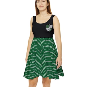May include: A black and green dress with a white chevron pattern. The dress has a black bodice with a green and silver crest on the front. The crest features a snake.