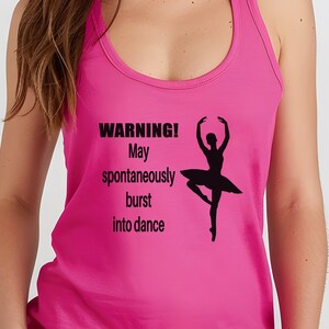 Puede incluir: Camiseta de tirantes rosa con una silueta negra de una bailarina y el texto "¡ADVERTENCIA! Puede estallar espontáneamente en danza."