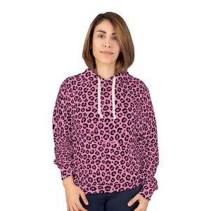 Peut inclure: Un sweat à capuche rose avec un motif léopard noir.