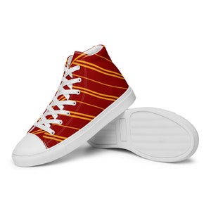 May include: White high-top canvas sneakers with red and yellow striped pattern.