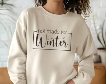 Puede incluir: Una sudadera beige con el texto "not made for Winter" impreso en negro.
