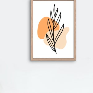May include: A framed print with a minimalist design featuring a black line drawing of a leaf with two orange and peach abstract shapes behind it.