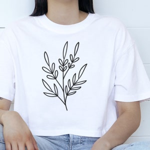 May include: A white cropped t-shirt with a simple black line drawing of a leafy branch.