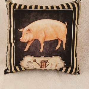 May include: A black and white striped pillow with a square image of a pink pig in the center. The image also includes a watering can, a stool, and a milk pail.