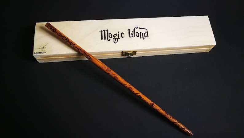 May include: A wooden wand with intricate carvings and the words "Magic Wand" inscribed on a wooden box.