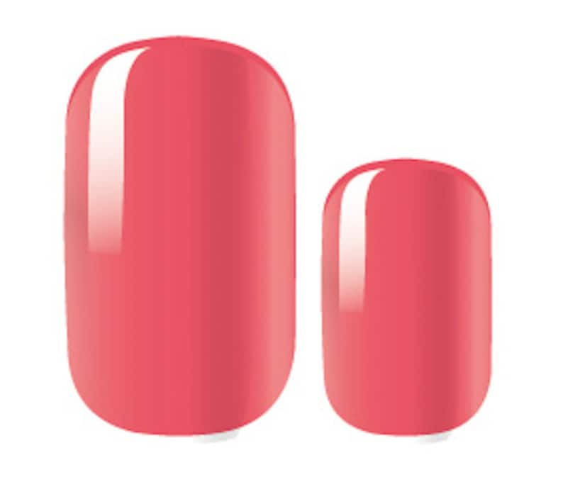 May include: Two oval-shaped press-on nails in a light coral color. The nails have a glossy finish.