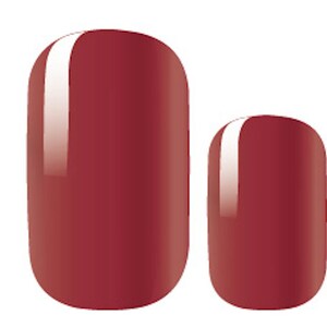 May include: Two red nail polish wraps, one larger and one smaller, with a glossy finish.