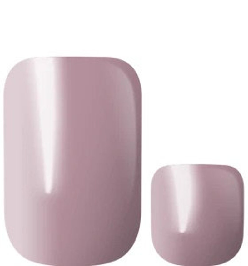 May include: Two sets of nude-colored press-on nails. The larger set is oval-shaped, while the smaller set is square-shaped.