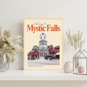 Könnte beinhalten: Gerahmter Druck mit einem Vintage-Bild eines Gebäudes mit Uhrturm, roten Bäumen und dem Text "Welcome to Mystic Falls". Darunter steht "nothing bad ever happens here".