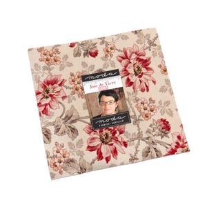 May include: Square fabric bundle with a floral pattern in shades of red, pink, and beige. The fabric features large, detailed flowers and foliage. A label with the text "Joie de Vivre" and a woman's portrait is attached. The fabric is likely for quilting or crafting.