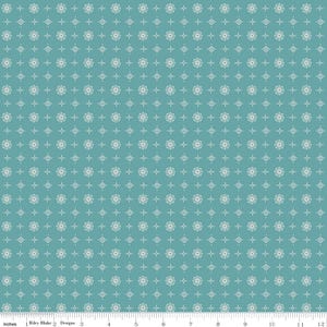 May include: Teal fabric with a repeating pattern of white floral and geometric shapes. The fabric has a ruler along the bottom edge, with the text "Inches" and "Riley Blake Designs".